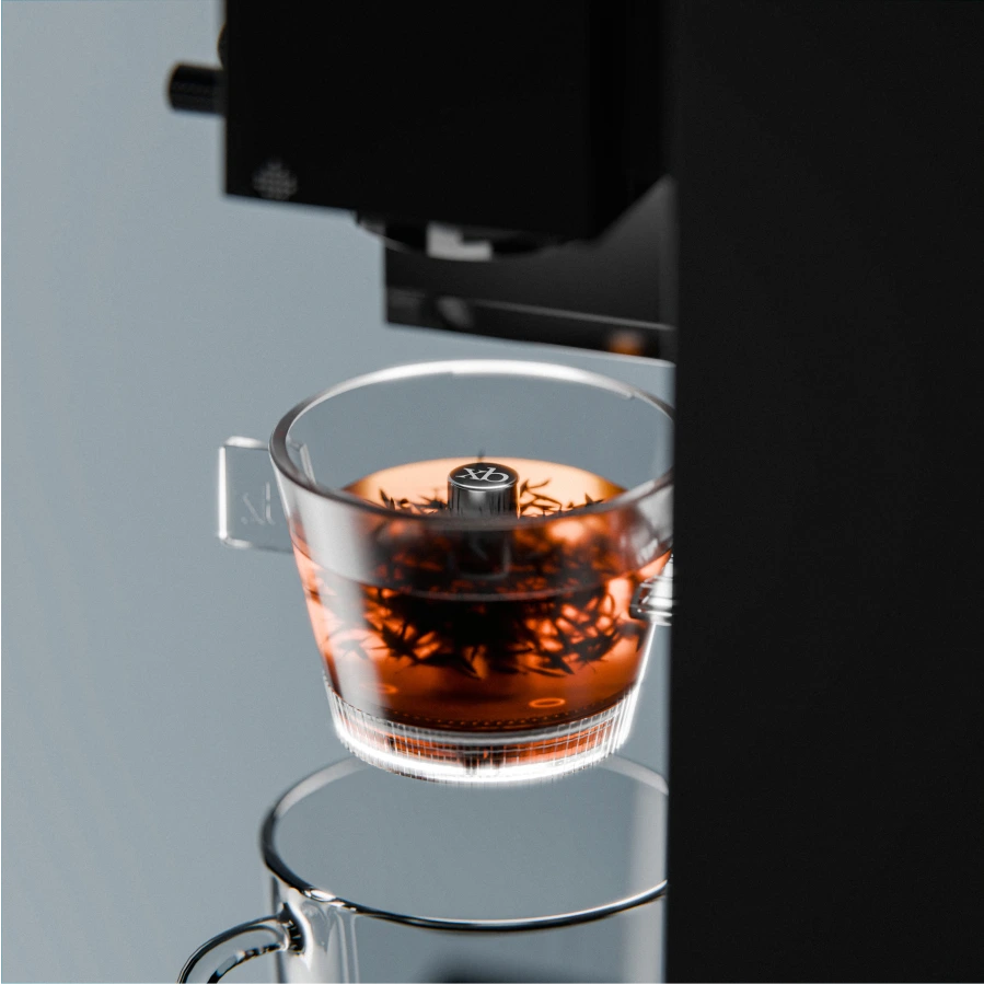 Glass of dark liquid with a coffee machine in the background