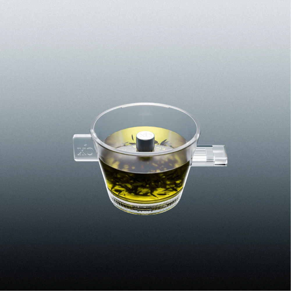 Clear omni tea dripper with a tea infuser on a gray background