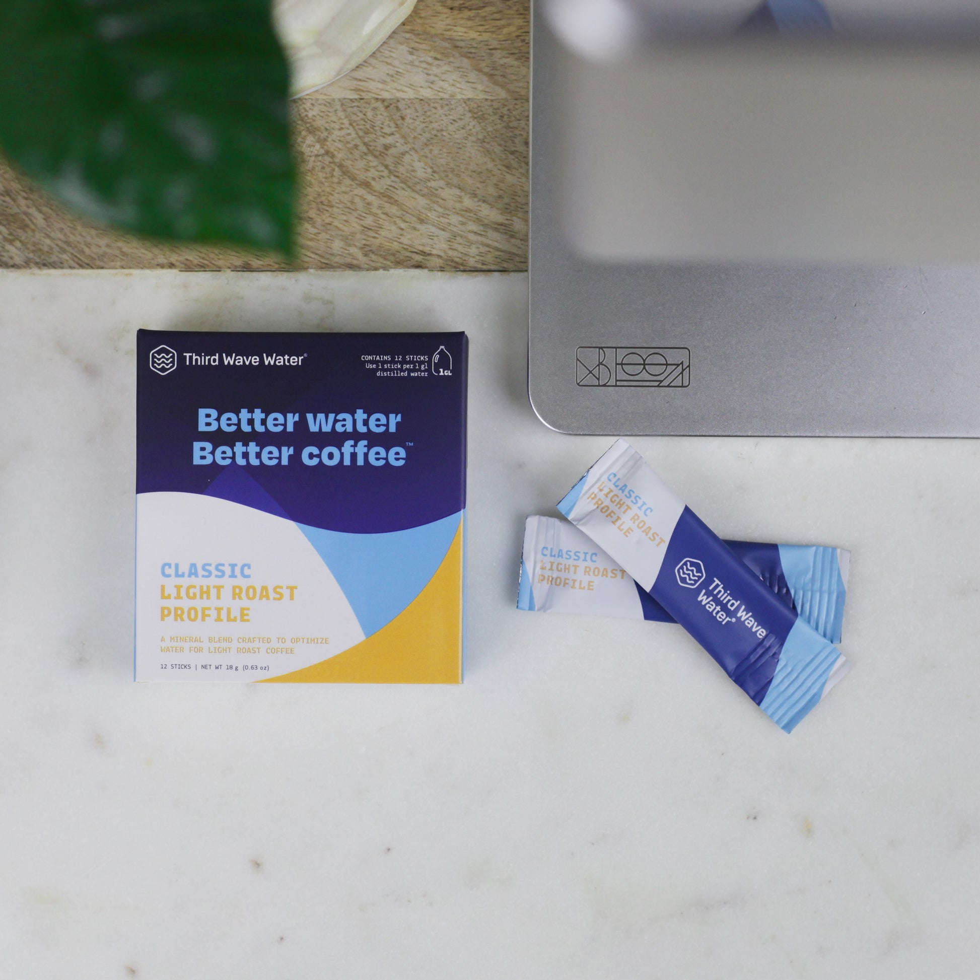 Third Wave Water Classic Light Roast coffee mineral blend box and single-serve packets, arranged on a marble kitchen countertop