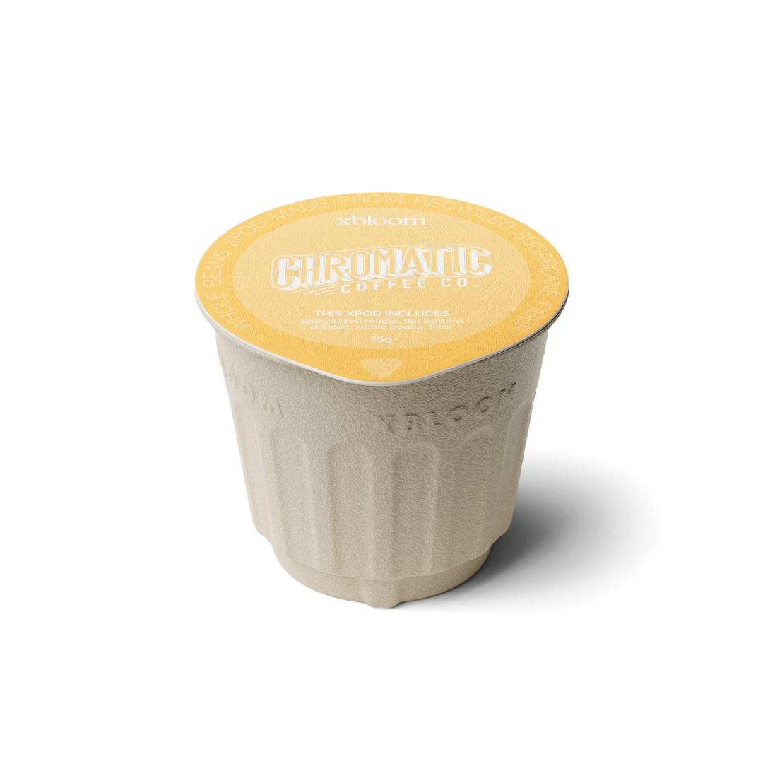 Single-serve coffee cup with yellow lid and branding on a white background