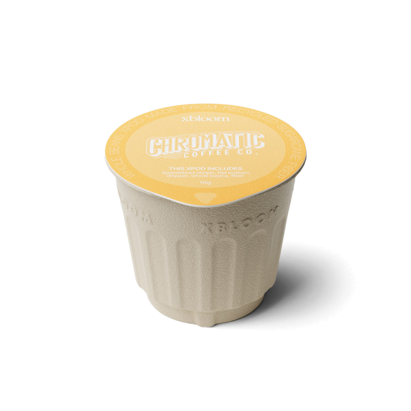 Single-serve coffee cup with yellow lid and branding on a white background