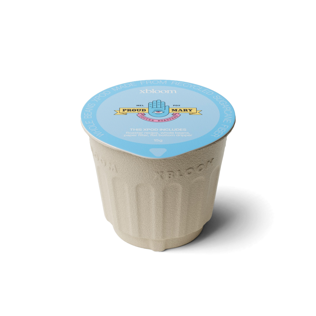 xBloom x Proud Mary coffee pod with a blue lid on a white background