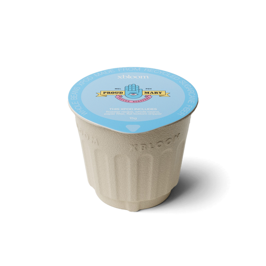 xBloom x Proud Mary coffee pod with a blue lid on a white background