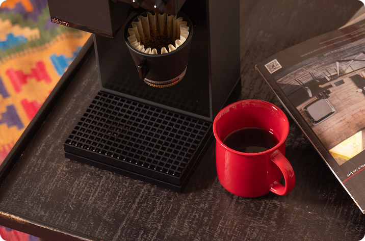 Red mug with coffee next to the xbloom Studio.