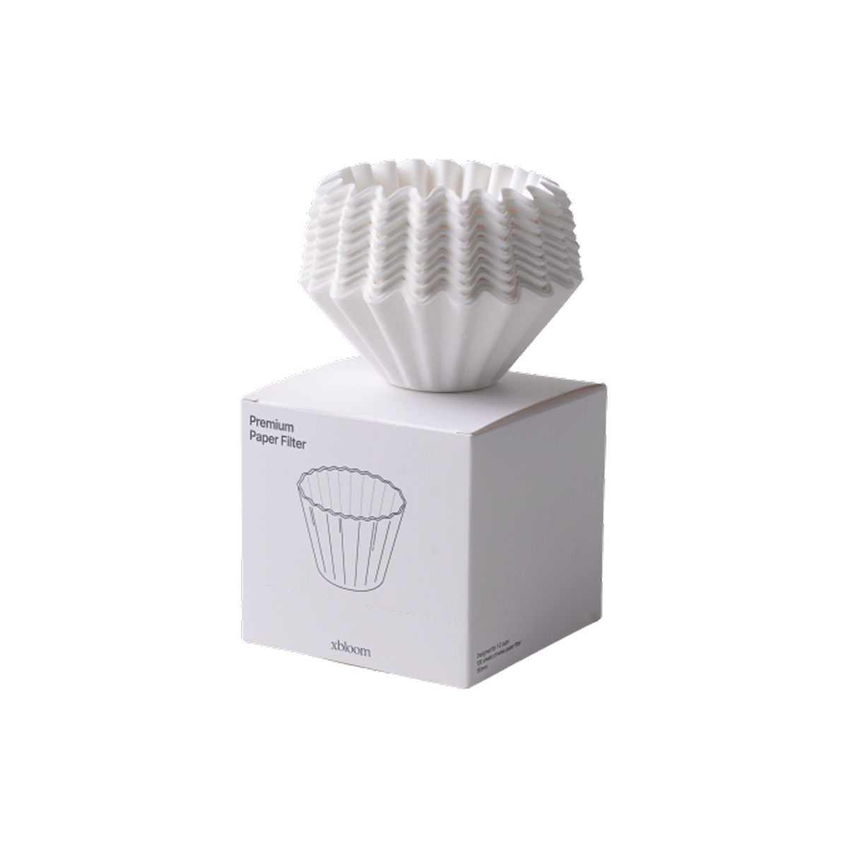 A white pleated paper coffee filter resting on top of its white retail box, photographed on a clean white background. The box has a simple line drawing of the filter and the text 'Premium Paper Filter' and '84mm'.